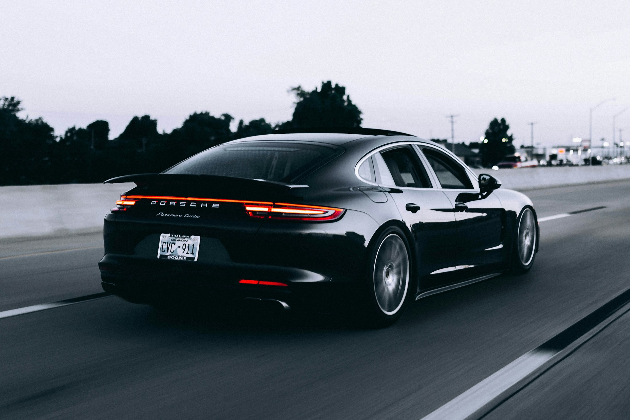 Stříbrné Porsche na silnici v zelené krajině